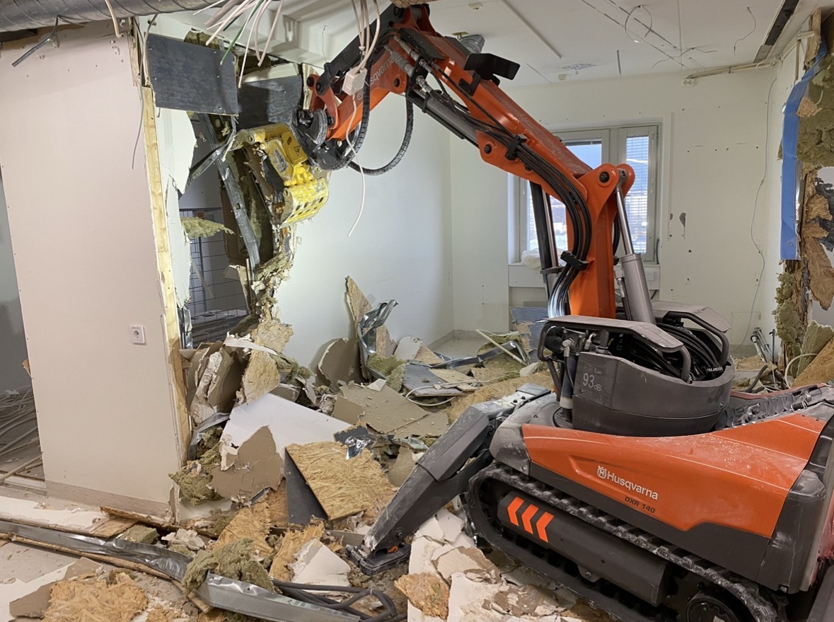 Fjärrstyrd rivningsrobot av modell Husqvarna DXR river en innervägg inomhus